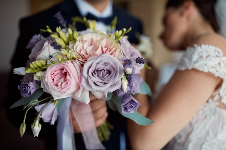 Une femme en robe de mariée tient un bouquet de fleurs